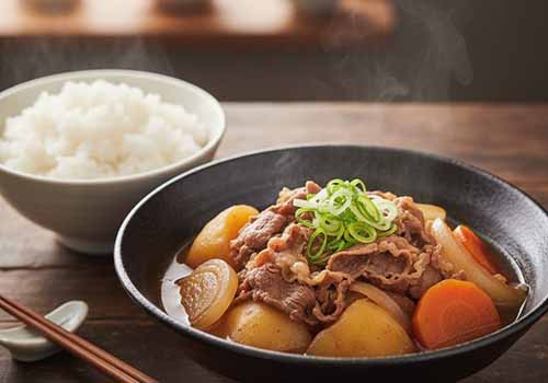 fines tranches de bœuf, de pommes de terre, de carottes et d'oignons, cuits doucement dans une sauce légèrement sucrée et salée à base de sauce soja, de mirin et de saké.