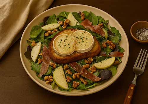 Salade de Chèvre Chaud servie dans une assiette en gré