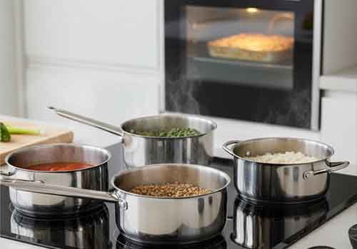 Une cuisine moderne ou mijotent des plats sur une plaque de cuisson et un four dans lequel cuit un gratin